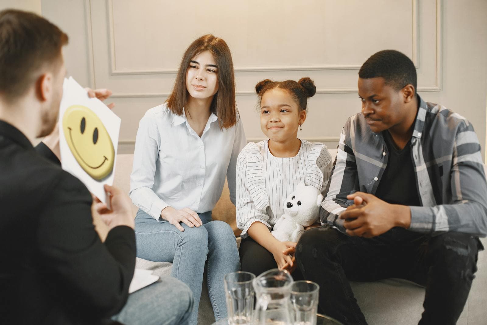 A family sits with a therapist during a calm session about emotions and support.