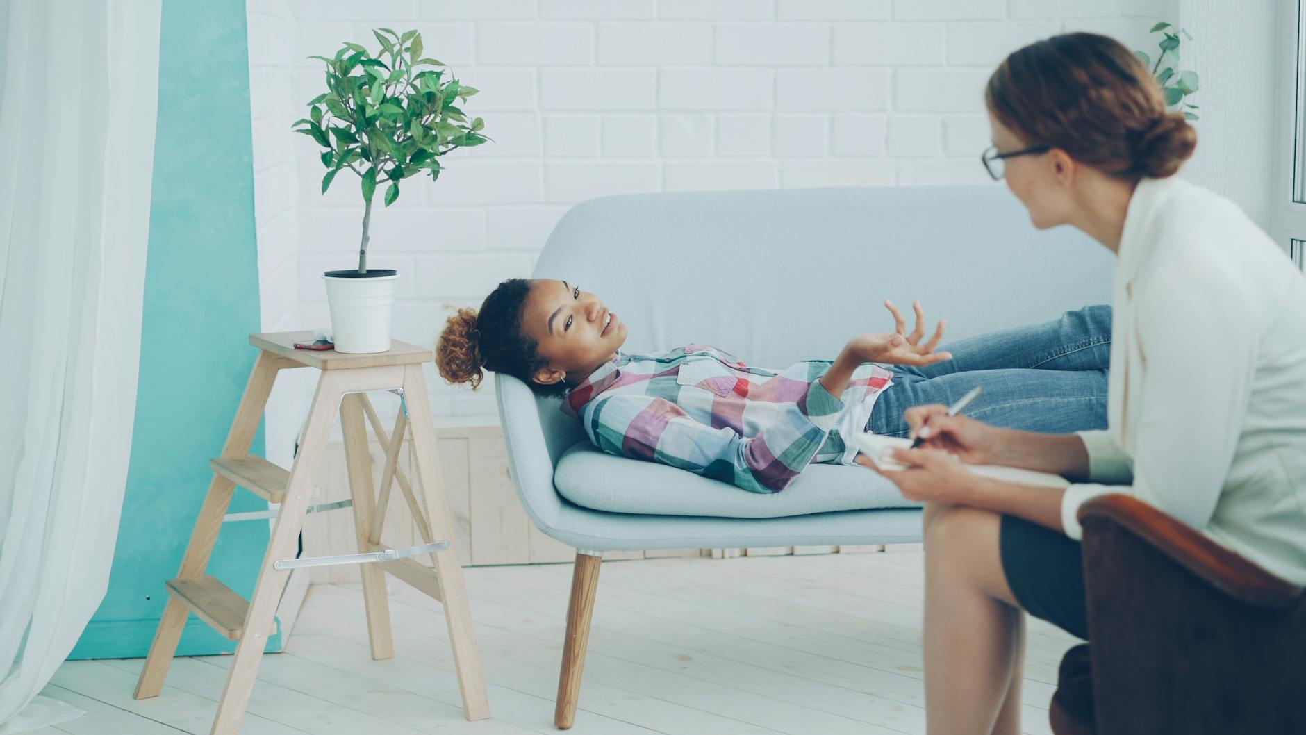 A woman sits at her kitchen table, scrolling through therapist profiles on her laptop, trying to decide who to reach out to first.